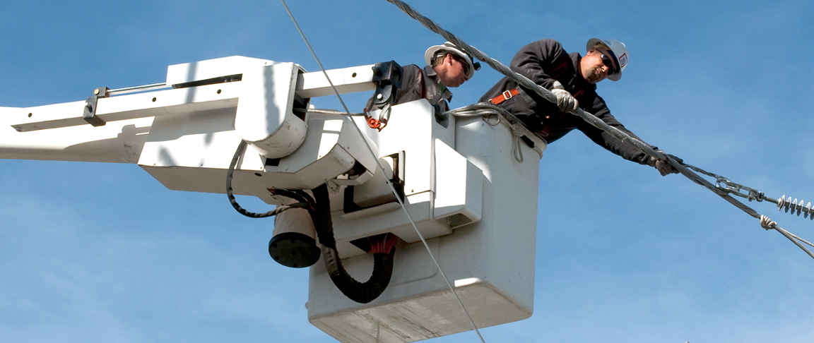 Linemen changing out poles and wires to complete the upgrade project